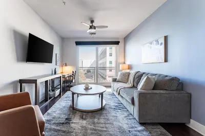 a living room with a couch and a table at Landing Stylish 1BD Rooftop Lounge Gym in Orlando