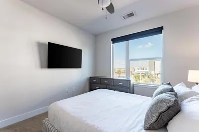 a bedroom with a bed and a flat screen tv at Landing Stylish 1BD Rooftop Lounge Gym in Orlando