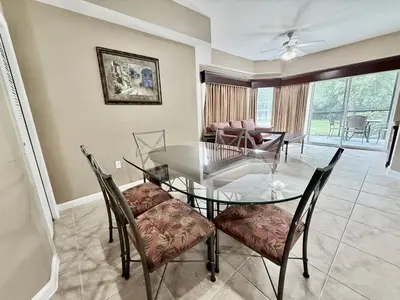 a dining room with a glass table and chairs at Entire Condo - 3Bed 2Bath- 5 mins to Disney Park in Orlando