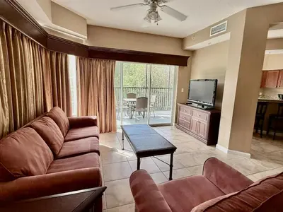 a living room with a couch and a television at Entire Condo - 3Bed 2Bath- 5 mins to Disney Park in Orlando