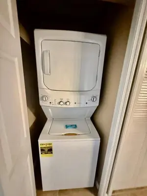 a washer and dryer sitting on top of a refrigerator at Entire Condo - 3Bed 2Bath- 5 mins to Disney Park in Orlando