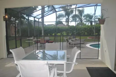 a patio with a table and chairs and a pool at Formosa Villa with Private Pool & 5 Miles to Disney in Orlando