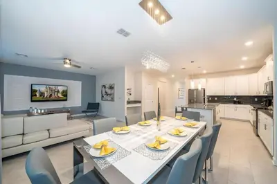 a dining room and kitchen with a table and chairs at Luxo com 6 Quartos e Piscina! – Storey Lake in Kissimmee