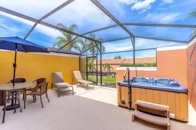 a patio with a hot tub and a table and chairs at 3027 Encantada in Kissimmee