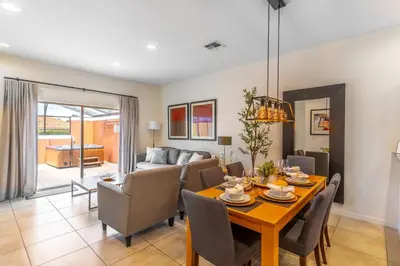 a dining room and living room with a table and chairs at 3027 Encantada in Kissimmee
