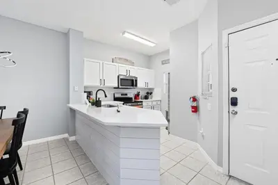a white kitchen with a sink and a microwave at Private Hot Tub Terra Verde Resort Pool Themed Rooms in Kissimmee