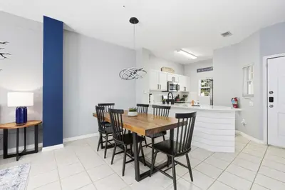 a kitchen and dining room with a wooden table and chairs at Private Hot Tub Terra Verde Resort Pool Themed Rooms in Kissimmee