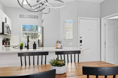 a kitchen with a wooden table and black chairs at Private Hot Tub Terra Verde Resort Pool Themed Rooms in Kissimmee