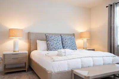 a bedroom with a large bed with two lamps at Beautiful 4-bedroom House with Splash Pool in Orlando