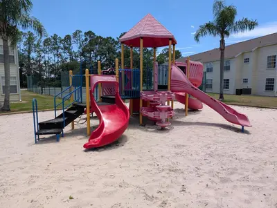 a playground in the sand with slides and an umbrella at Great for Families 1-4 Kids! Near Disney, Universal, Shopping, Dining in Kissimmee