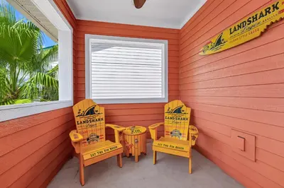 a porch with two chairs and a window at Dreamy Coral Cottage With Hot Tub Near Disney With Margaritaville Resort & Island H2O Waterpark Access - 3062Pi in Orlando