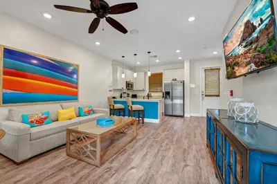 a living room with a couch and a table at Dreamy Coral Cottage With Hot Tub Near Disney With Margaritaville Resort & Island H2O Waterpark Access - 3062Pi in Orlando