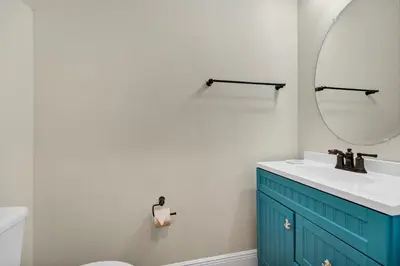 a bathroom with a blue cabinet and a mirror at Dreamy Coral Cottage With Hot Tub Near Disney With Margaritaville Resort & Island H2O Waterpark Access - 3062Pi in Orlando