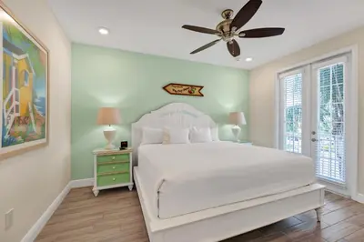 a bedroom with a white bed and a ceiling fan at Lush Garden Oasis Cottage Near Disney With Margaritaville Resort And Island H2O Waterpark Access - 8016Ff in Orlando