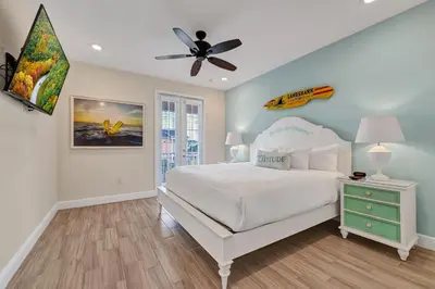 a bedroom with a white bed and a ceiling fan at Lush Garden Oasis Cottage Near Disney With Margaritaville Resort And Island H2O Waterpark Access - 8016Ff in Orlando