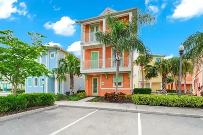 a building with palm trees in front of a parking lot at Lush Garden Oasis Cottage Near Disney With Margaritaville Resort And Island H2O Waterpark Access - 8016Ff in Orlando