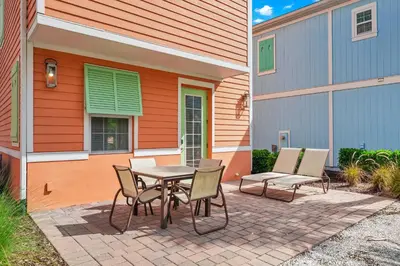 a patio with a table and chairs next to a building at Lush Garden Oasis Cottage Near Disney With Margaritaville Resort And Island H2O Waterpark Access - 8016Ff in Orlando