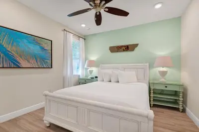 a bedroom with a white bed and a ceiling fan at Lush Garden Oasis Cottage Near Disney With Margaritaville Resort And Island H2O Waterpark Access - 8016Ff in Orlando