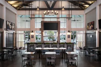 a dining room with tables and chairs and a flat screen tv at SpringHill Suites by Marriott Orlando at FLAMINGO CROSSINGS Town Center-Western Entrance in Orlando