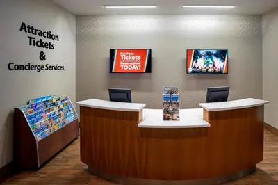 a waiting room with a counter with two chairs at SpringHill Suites by Marriott Orlando at FLAMINGO CROSSINGS Town Center-Western Entrance in Orlando