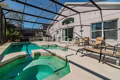 a swimming pool with chairs and a house at Casa Térrea 5Q c/ Piscina — 15min da Disney in Kissimmee