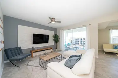 a living room with a white couch and a tv at Resort Condo 10 Min to Disney in Kissimmee