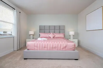 a bedroom with a pink bed and two lamps at Stylish Property with Private Pool in Orlando