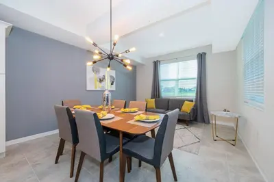 a dining room and living room with a table and chairs at Amazing Condo Getaway in Kissimmee