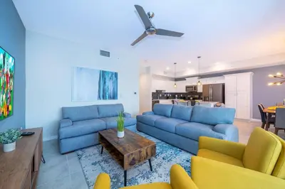 a living room with blue couches and a table at Amazing Condo Getaway in Kissimmee