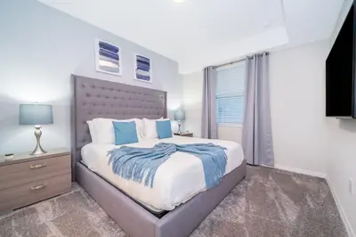 a bedroom with a large bed and a television at Amazing Condo Getaway in Kissimmee