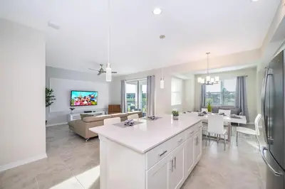 a kitchen and living room with a couch and a table at Modern Condo Near Disney in Kissimmee