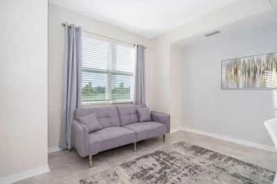 a living room with a couch and a window at Modern Condo Near Disney in Kissimmee