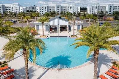 an overhead view of a large swimming pool with palm trees at Modern Condo Near Disney in Kissimmee