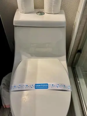 a white toilet with a sticker on the lid at Modern 4BR 2BA with pool in gated community in Kissimmee