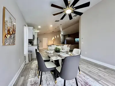 a dining room and kitchen with a table and chairs at Modern 4BR 2BA with pool in gated community in Kissimmee