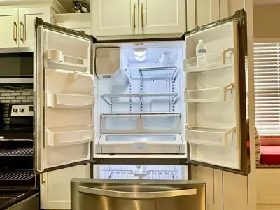 a refrigerator with its door open in a kitchen at Modern 4BR 2BA with pool in gated community in Kissimmee