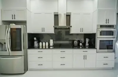 a kitchen with white cabinets and a stainless steel refrigerator at Luxury Disney Retreat in Kissimmee