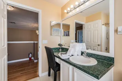 a bathroom with a sink and a mirror at 5Q/3B Vista p/ Lago *Piscina Priv.* in Kissimmee