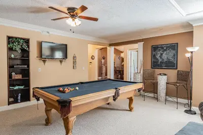 a pool table in a living room with a ceiling fan at 5Q/3B Vista p/ Lago *Piscina Priv.* in Kissimmee