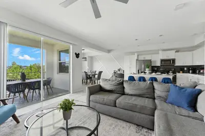 a living room with a couch and a dining room at Spacious 2BR Mickey Bedroom Lake View in Kissimmee