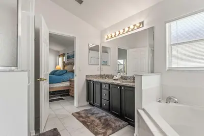 a bathroom with a tub and a sink and a mirror at Magical Family Getaway - 10ppl in Kissimmee