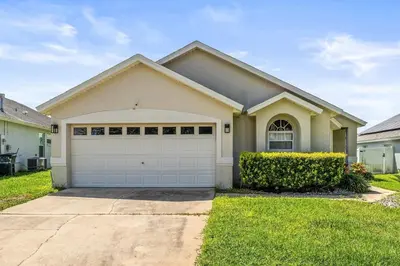 a house with a white garage in a yard at Magical Family Getaway - 10ppl in Kissimmee