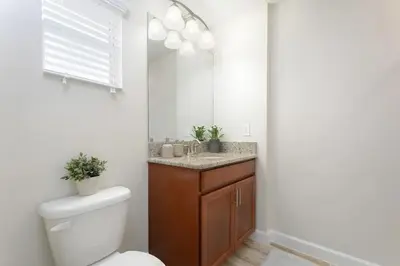 a bathroom with a toilet and a sink with a mirror at Casa Espaçosa + Piscina Privada + Resort TOP in Kissimmee