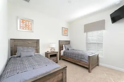 a bedroom with two beds and a flat screen tv at Casa Espaçosa + Piscina Privada + Resort TOP in Kissimmee