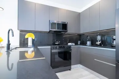 a kitchen with white cabinets and a black stove top oven at Modern 3Bd Screened Pool at Serenity Resort 17322 in Orlando