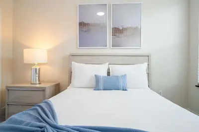 a bedroom with a large bed with blue and white pillows at Modern 3Bd Screened Pool at Serenity Resort 17322 in Orlando