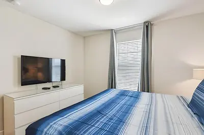a bedroom with a bed and a flat screen tv at Casa Luxo Storey Lake | 6 quartos + Piscina in Kissimmee