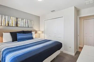 a bedroom with a blue bed and a white wall at Casa Luxo Storey Lake | 6 quartos + Piscina in Kissimmee