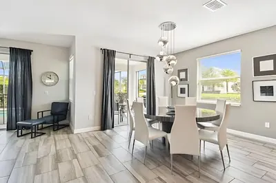 a dining room and living room with a table and chairs at Casa Luxo Storey Lake | 6 quartos + Piscina in Kissimmee