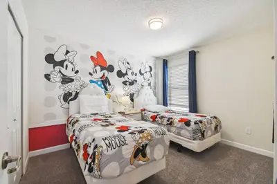 a bedroom with two beds with mickey mouse wallpaper at Casa Luxo Storey Lake | 6 quartos + Piscina in Kissimmee